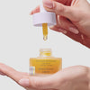 Video of hand holding the beekman 1802 Golden Booster Amla Berry Vitamin C Brightening Serum while holding the dropper in the other hand